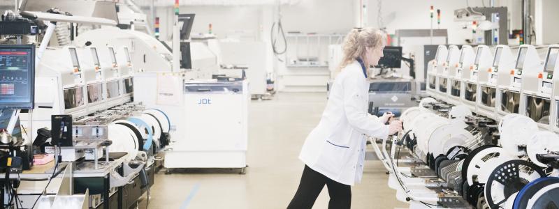 Projektledare arbetar med SMT-maskin i industrilabb. Foto: Bredda bilden